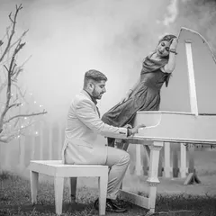 A dreamy, romantic scene with a white piano in a misty outdoor setting. This black and white photo looks like a still from a classic movie, full of mood and atmosphere.