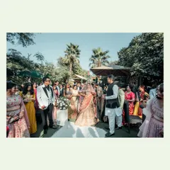 A wide shot of the wedding ceremony, showing the couple surrounded by all their guests. This image captures the scale of the celebration and the community of loved ones present.