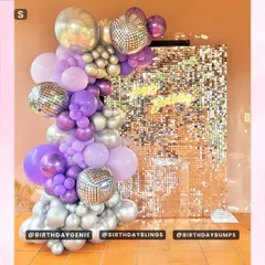 This purple and silver disco theme uses a gold shimmer wall for a warm contrast. The balloon garland is filled with purple, lavender, and silver, with disco balls mixed in for extra shine.