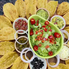 Our build-your-own Taco Platter is the life of any party. It comes with our handmade crispy taco shells, fresh lettuce, a vibrant pico de gallo, classic guacamole, sweet mango salsa, and hearty refried beans.