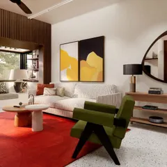 The living room in HAUS 5 is an eclectic mix of colors, textures, and forms. A bold red rug anchors the space, which features a comfortable window seat, modern art, and a mix of contemporary and classic furniture pieces.