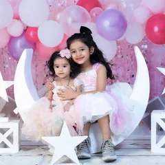 Sisterly love on our moon and stars set. This setup is perfect for sibling photoshoots, especially for birthdays or special milestones. The pastel balloons add a celebratory touch.