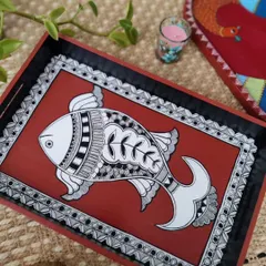 This hand-painted wooden tray features a fish motif in the traditional Madhubani style. It's a beautiful and functional piece, perfect for serving guests or as a decorative accent.