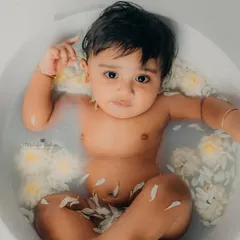 A calm moment in the tub. The flower petals floating in the water add a beautiful, gentle touch to the photo.