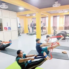 Students use yoga straps in Navasana (Boat Pose) to support their posture and build core strength effectively.