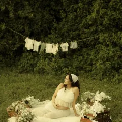 Relaxing in a beautifully styled outdoor setting. This shot captures a candid moment from the picnic-themed session, showcasing the thoughtful details like the flower baskets and vintage chest.