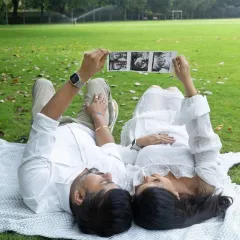 A creative and sweet shot of the couple lying on a blanket, holding their sonogram pictures up to the sky. A beautiful way to dream about their future.