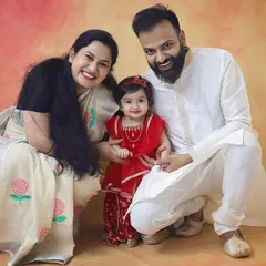 A happy family celebrating Janmashtami together. Their coordinated traditional outfits and big smiles make this such a warm and festive portrait.