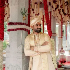 For the distinguished groom, we crafted this elegant silk sherwani in a classic cream color. The subtle embroidery on the collar and cuffs adds a touch of royalty, making it a perfect choice for a traditional wedding ceremony.