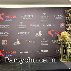 We create custom-printed backdrops that prominently feature event sponsors and partners. This step-and-repeat banner is framed with elegant gold and white floral arrangements for a polished look.