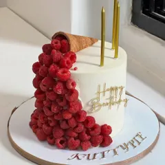 When elegance meets indulgence. This modern cake design features fresh raspberries cascading from a cone, complemented by clean lines and golden details for an unforgettable birthday moment.