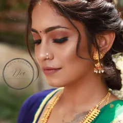 A close-up of this natural bridal makeup. The eyeshadow is soft and earthy, the skin looks fresh, and the messy updo with jasmine flowers adds a touch of effortless South Indian charm.