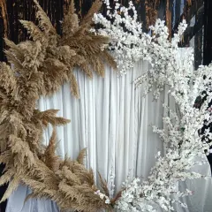 A different angle of the pampas and blossom backdrop, showing how the contrasting elements create a visually interesting frame against a simple white curtain.