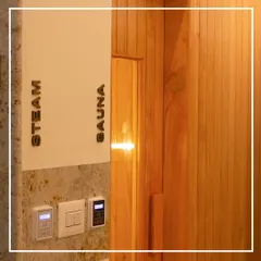 Modern wellness amenities, like these new steam and sauna rooms, are seamlessly integrated into the heritage setting of the Bangalore Club. The design uses warm wood paneling and clear signage to create a functional, spa-like experience that respects the original structure.