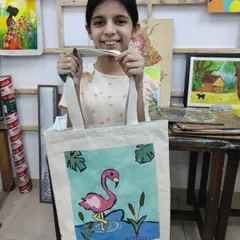 This young artist painted a vibrant flamingo on her tote bag. We provide a variety of designs and full guidance to help every child create a masterpiece.