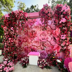 A fun and floral photo booth for a Mehendi, featuring a swing set against a backdrop of pink peonies and framed by an explosion of colorful flowers.