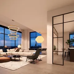 This wide-angle interior shot of a rooftop lounge highlights the open-concept design, connecting the living area with a dining space and kitchen. The expansive windows provide an immersive view of the city at twilight.
