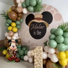 We brought the safari to the party for Makar's first birthday. This jungle-themed setup features a Mickey Mouse safari character, animal print details, and a balloon arch in earthy green, brown, and yellow tones.