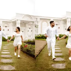 Running hand-in-hand through a pristine white garden. The all-white theme of the location and their outfits creates a pure, elegant, and joyful pre-wedding photograph.