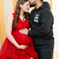 A gentle forehead kiss is a simple but powerful expression of love and protection. This close-up shot focuses on the tender bond between the expecting parents.
