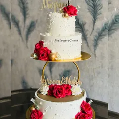 A classic two-tier wedding cake with a separator, adorned with beautiful red roses and delicate pearl details. This design offers a grand presence, perfect for your special day.