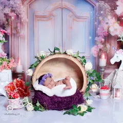 Here, the baby is nestled in a wooden bark bowl, surrounded by flowers and our beautiful floral gate backdrop.