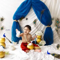 The cutest little Makhan Chor! This little Kanha is having so much fun pretending to eat butter from the pot. These playful shots are always a favourite.