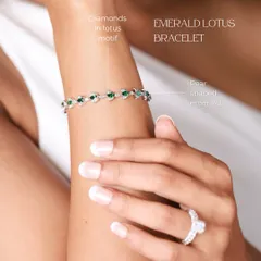 The Emerald Lotus Bracelet worn on the wrist. This design features pear-shaped emeralds and diamonds set in a delicate lotus motif, symbolizing purity and beauty.