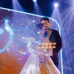 A dreamy portrait of the couple on stage, captured with a creative prism effect that enhances the magical lighting.