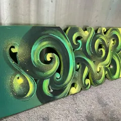 A side angle of the carved skateboard, showing the texture and dimension of the Hindi lettering.