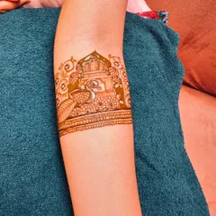 This armband showcases a detailed peacock sitting within a jharokha (ornate window), a beautiful and artistic piece of henna for the upper arm.