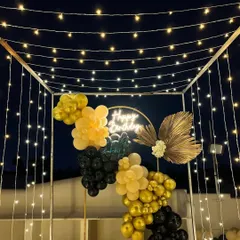 A beautiful shot of the terrace birthday decor against the night sky. The string lights create a starry effect above the balloon arrangement.
