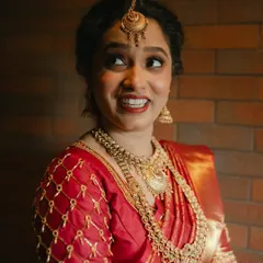 A happy, candid moment from her South Indian wedding. The makeup is designed to be long lasting and radiant, capturing her joy perfectly.