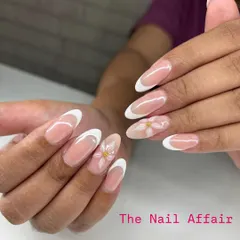 I love putting a creative spin on a classic. This is a timeless French manicure on almond extensions, elevated with delicate, hand-painted white daisies on the accent nails for a touch of spring.