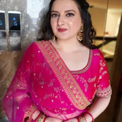 This client is glowing in her vibrant pink lehenga. I created a soft glam makeup look with a focus on luminous skin and defined eyes, paired with voluminous curls for a festive feel.