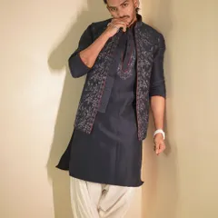 Influencer Shadab Khan showcases a contemporary look with this dark navy kurta and embroidered jacket set. Paired with traditional dhoti-style pants, it's a bold fusion of styles.