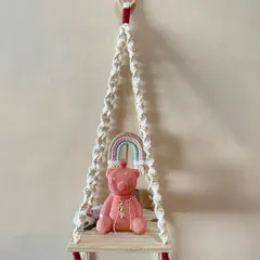 A simple and elegant macrame shelf. The spiral knots and minimal design make it a versatile piece that can hold a small plant, a candle, or other treasures.
