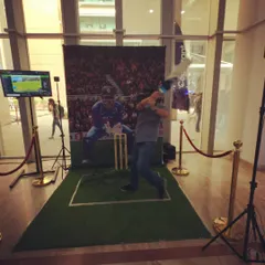 A participant mid-swing, fully immersed in the VR cricket experience. The combination of the headset and physical bat makes every shot feel real, providing great entertainment for both the player and the audience.