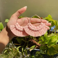 Our boho fringe macrame earrings are lightweight and make a beautiful statement. These hoop earrings feature soft, baby pink knotted details and a fringed edge for a touch of bohemian style.