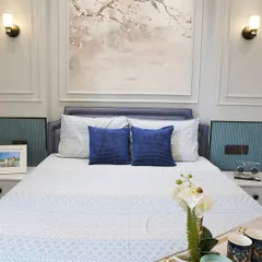 A serene bedroom where the artwork sets the mood. The soft, dreamy painting of cherry blossoms is the focal point, with the rest of the room designed in calming blues and whites to create a peaceful retreat.