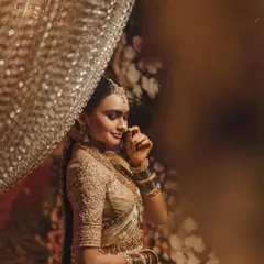 An artistic shot of a bride in a golden Kanchipuram saree. The intricate, fully embroidered blouse is the highlight, showcasing our commitment to detailed craftsmanship for every bridal look.