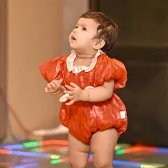 An outfit change for the birthday girl! This candid shot captures her looking up with wonder, a perfect memory from her first birthday event photography session.
