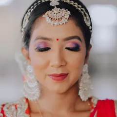 A serene portrait with eyes closed, allowing a full view of the beautiful purple and pink eyeshadow. This is a great shot for a makeup artist's portfolio and for brides looking for inspiration.