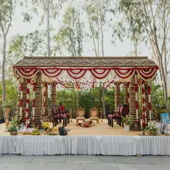 This outdoor mandap, set against a backdrop of rolling hills, is a beautiful example of blending tradition with nature. The carved pillars and floral arrangements are inspired by classic South Indian temple architecture.