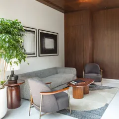 A cozy family lounge area featuring a warm wood-paneled ceiling and comfortable, modern furniture. This space is designed as a social hub for daily interactions and relaxed gatherings.
