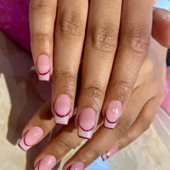 A minimalist yet chic take on the French manicure, featuring a clean, sheer pink base with a fine, deep red line tracing the cuticle for a unique, reversed effect.