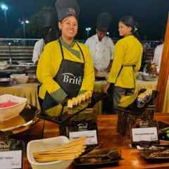 My smiling chef at the sushi station, presenting a platter of freshly prepared rolls, showcasing the friendly service I provide.