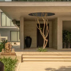 The entrance is marked by a circular void in the concrete roof, through which a tree grows. This gesture creates a powerful dialogue between the man-made structure and the natural world.