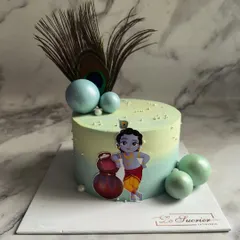 Celebrating Janmashtami with a modern twist on a classic theme. This cake is decorated with a peacock feather, edible spheres, and a cute illustration of Kanha, making it perfect for the occasion.