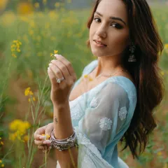 A beautiful portrait of the bride-to-be in a field of mustard flowers, her serene expression and the golden surroundings creating a dreamy, romantic image.